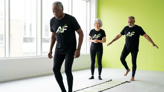 Adults 55+ stepping through an agility ladder for balance and footwork