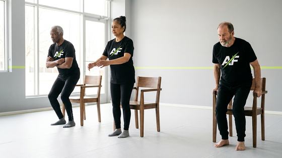 Adults over 60 practising the chair-to-stand movement in class